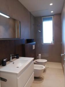 马斯卡利Villa sul mare Dambra Apartment的浴室配有白色水槽和卫生间。