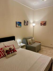 米兰GARIBALDI ISOLA APARTMENTS的一间卧室配有一张床、一张沙发和一把椅子