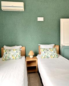 弗利康弗拉克Azur - Résidence Le Dattier的绿墙客房的两张床