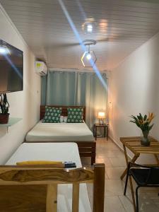 奇特雷Hostel Travelers Chitre的客房设有两张床、一台电视和一张桌子。