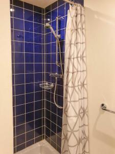 萨斯尼茨苏姆斯坦沃格特公寓的带淋浴的浴室和蓝色瓷砖墙