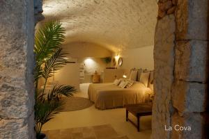 AvinyonetCal Mestre Casa Rural的一间卧室设有一张床和石墙