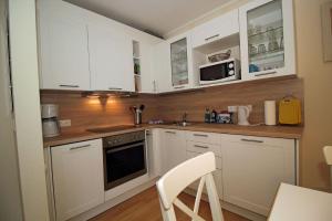 萨斯尼茨Villa Seeblick Apartment 307的厨房配有白色橱柜和炉灶烤箱。