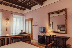 佛罗伦萨II Guelfo Bianco的一间卧室配有书桌、镜子和桌子