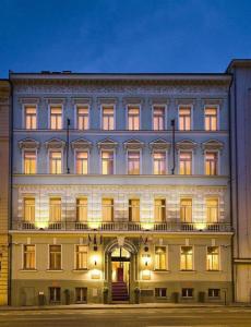 布拉格Hotel Raffaello Prague的一座白色的大建筑,灯火通明