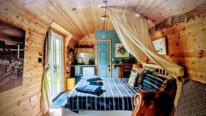 霍利韦尔Emlyn's Coppice - Luxury Woodland Glamping的小木屋内一间卧室,配有一张床
