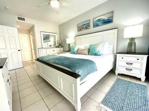 乔治敦Regal Beach Club #322的卧室配有带蓝色枕头的大型白色床