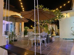 Sungai PelikSuria 3 Sepang with private pool的一个带桌椅和遮阳伞的庭院