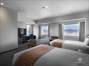 广岛Daiwa Roynet Hotel Hiroshima-ekimae的酒店客房设有两张床和电视。