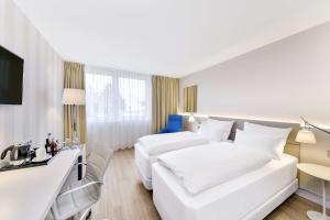 魏因海姆魏英海姆NH酒店的酒店客房配有两张床和一张书桌