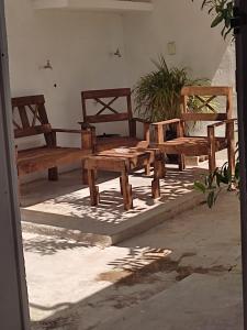 梅里达HOSPEDAJE MAGNOLIAS MERIDA的坐在庭院里的一组木凳