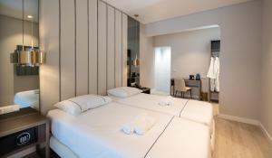 里斯本AMMA Lisboa Hotel的酒店客房,配有两张带毛巾的床