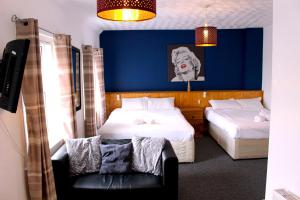 布莱克浦游乐海滩亨森酒店的一间卧室设有两张床和蓝色的墙壁