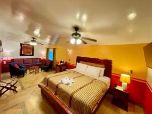 帕伦克金塔夏娜布娜精品酒店的一间卧室设有一张床和一间客厅。