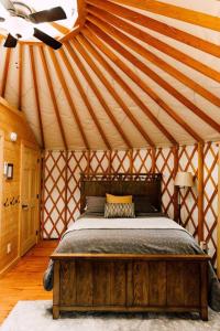 布赖森城Tuckaseegee @ Sky Ridge Yurts的蒙古包内一间卧室,配有一张木床