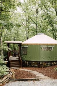 布赖森城Tuckaseegee @ Sky Ridge Yurts的绿色帐篷,在树林里设有甲板