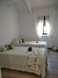 马德里德霍斯Finca El Pilar的白色卧室配有两张床和一盏灯