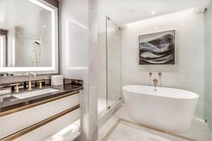 温哥华AZUR Legacy Collection Hotel的白色的浴室设有浴缸和水槽。