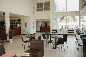 巴拉那Hotel Posta del Sol Paraná的大型客房设有桌椅和窗户。