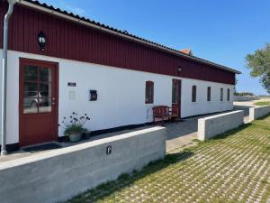 维比Vita og Pouls Gård - Guesthouse的红色和白色的建筑,有红色的门