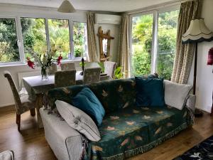 PorthallowFuchsia Cottage的带沙发、桌子和窗户的客厅