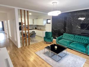 Moşniţa NouăCiki’s modern apartament的客厅配有绿色沙发和桌子
