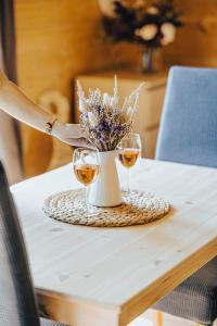 比尔森Chata louka的一张桌子,上面放着两杯酒,花瓶上放着鲜花