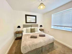 桑盖特Folkestone 3 Bedroom with private parking and EV car outlet near M20 easy access to Eurotunnel, Dover & Dungeoness的一间卧室设有一张大床和一个窗户。