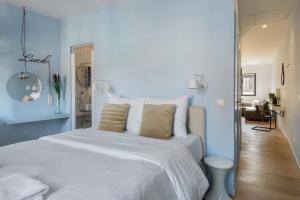安特卫普R73 Apartments by Domani Hotels的卧室配有白色的床和蓝色的墙壁