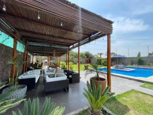 利马Casa en San Fernando Pachacamac的带沙发和游泳池的木制凉亭