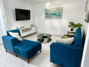 利马Casa en San Fernando Pachacamac的客厅配有2把蓝色椅子和电视