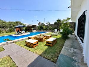 利马Casa en San Fernando Pachacamac的后院设有带桌椅的游泳池