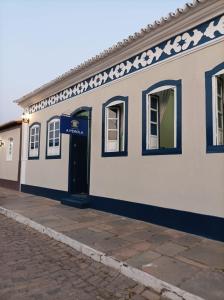 里奥迪孔塔斯Pousada A Pérola的一条白色的建筑,在街上有一扇蓝色的门