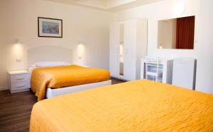 科莫Victoria Royal Garden的配有橙色床的酒店客房内的两张床