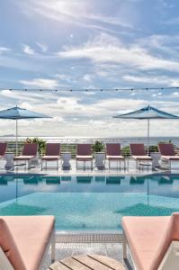 迈阿密Mr. C Miami - Coconut Grove的一个带躺椅和遮阳伞的游泳池