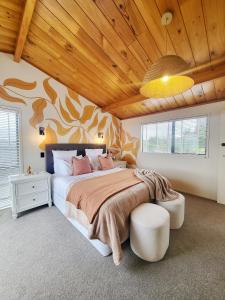 汉密尔顿Fiji Vibe 4 Bedroom Oasis in Rototuna North的一间卧室设有一张带木制天花板的大床