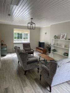 CastledawsonMillview Cottage的客厅配有沙发、椅子和桌子