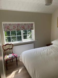CastledawsonMillview Cottage的卧室配有床、椅子和窗户。