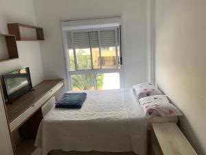 弗洛里亚诺波利斯Apartamento na Praia do Campeche的一间小卧室,配有床和窗户