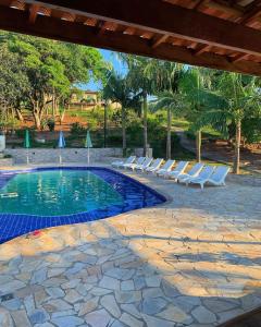塞拉内格拉Chalé Alto da Serra SP的毗邻度假酒店的带躺椅的游泳池