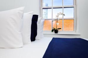 波士顿Modern Studio in Historic Boston - Unit #401的卧室配有带白色枕头的床和窗户。
