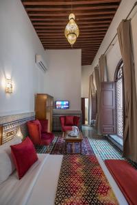 非斯Riad Fes Ziyat & Spa的酒店客房,配有床铺和红色椅子