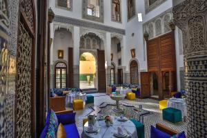 非斯Riad Fes Ziyat & Spa的大楼内带桌椅的餐厅