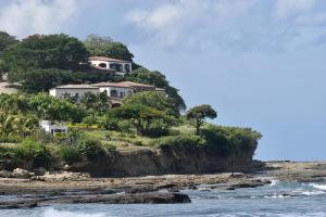 托拉Casa para 4 personas con A/C a 200 mts de la playa Low Tide - Popoyo Aparts的海边小山上的房子