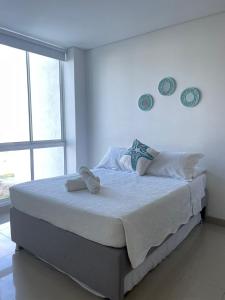 圣玛尔塔Reserva Del Mar的白色卧室配有一张大床和毛巾