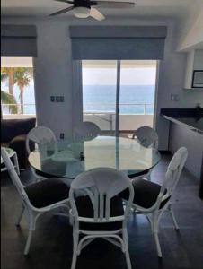 曼萨尼约DPTO. A orilla del Mar的一间设有玻璃桌和椅子的用餐室