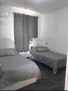 曼萨尼约DPTO. A orilla del Mar的客房设有两张床和窗户。
