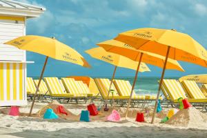 迈阿密海滩Hilton Cabana Miami Beach Resort的海滩上一群黄色的遮阳伞和椅子
