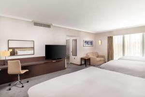 霍利希尔顿伦敦盖特威克机场酒店的酒店客房配有一张床和一张书桌及一台电视