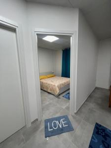 ElmasCasa Ilaria的小房间,有床和表示爱的标牌